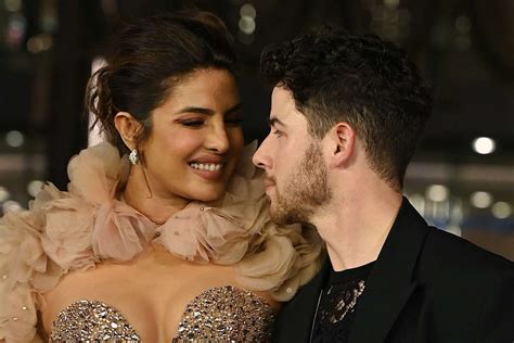 Nick Jonas is on hosting duty tonight at the Billboard Music Awards, and his wife Priyanka Chopra joined him for the big night. The two posed on the carpet together, Chopra wearing sheer nude plunge dress with a high leg slit by Dolce & Gabbana with Bulgari jewelry. Jonas went bold in a green Fendi suit.